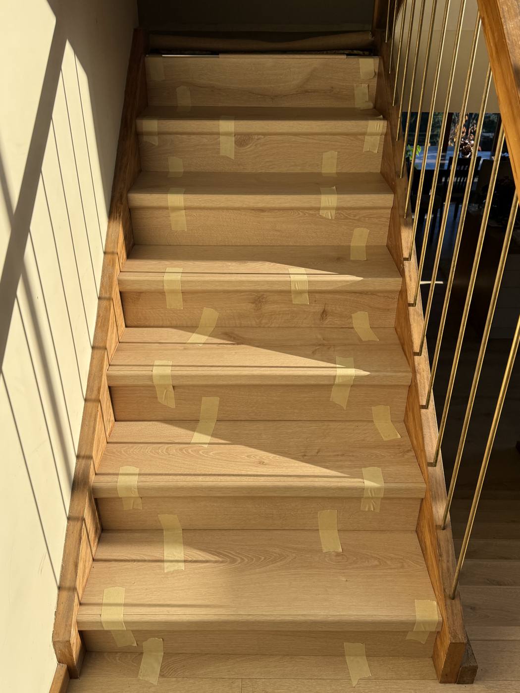 Open staircase with new treads taped in place while the adhesive cures
